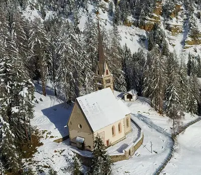 Vue aérienne de l’église Santa Giuliana au-dessus de Vigo di Fassa